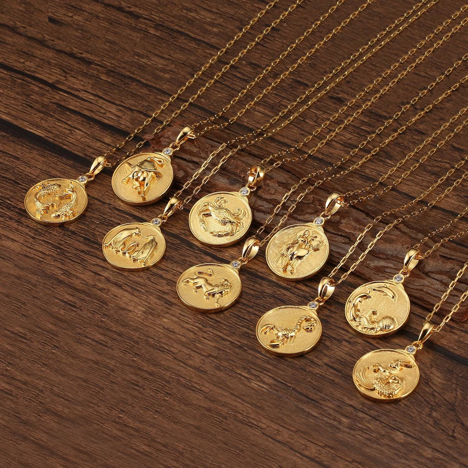 Grouping of various gold Zodiac Necklaces on wooden surface