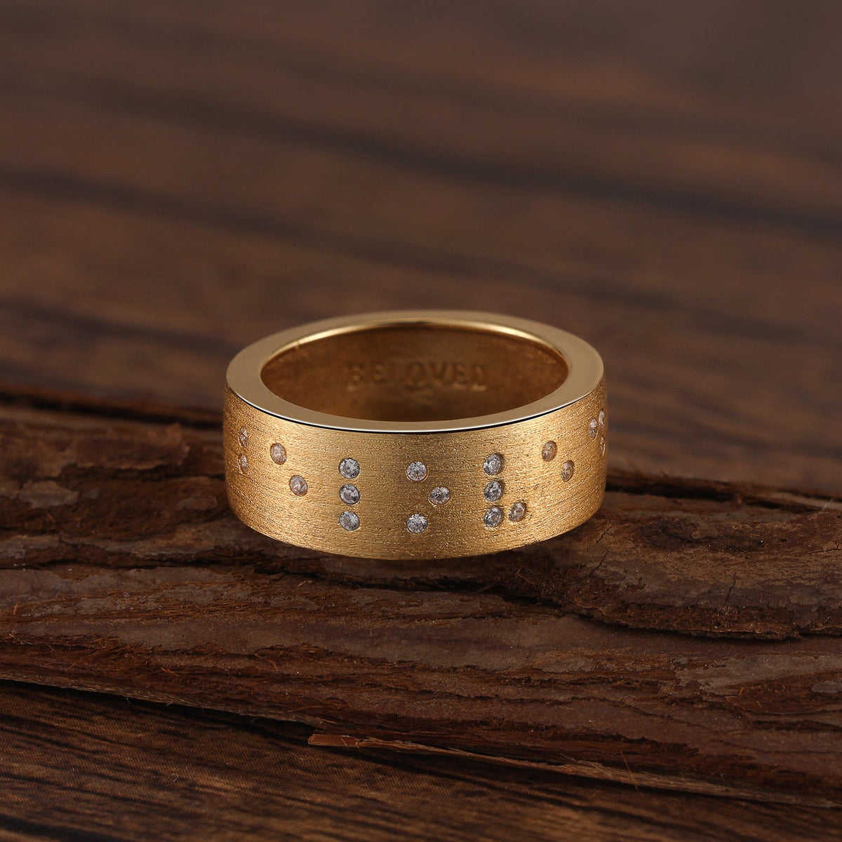 Touchstone Beloved Braille Crystals Band Ring Brushed Gold on Wooden Surface