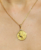 Gold Zodiac Necklace on a neckline to show scale