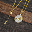 Gold and silver necklace with a Zodiac Leo lion pendant on a wooden surface