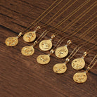 Grouping of various gold Zodiac Necklaces on wooden surface