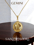 Gold necklace with a Gemini Zodiac pendant on a wooden surface