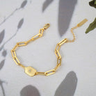 Gold bracelet with a decorative pickleball paddle design on a light background