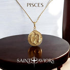 Gold necklace with a Pisces Zodiac pendant on a wooden surface