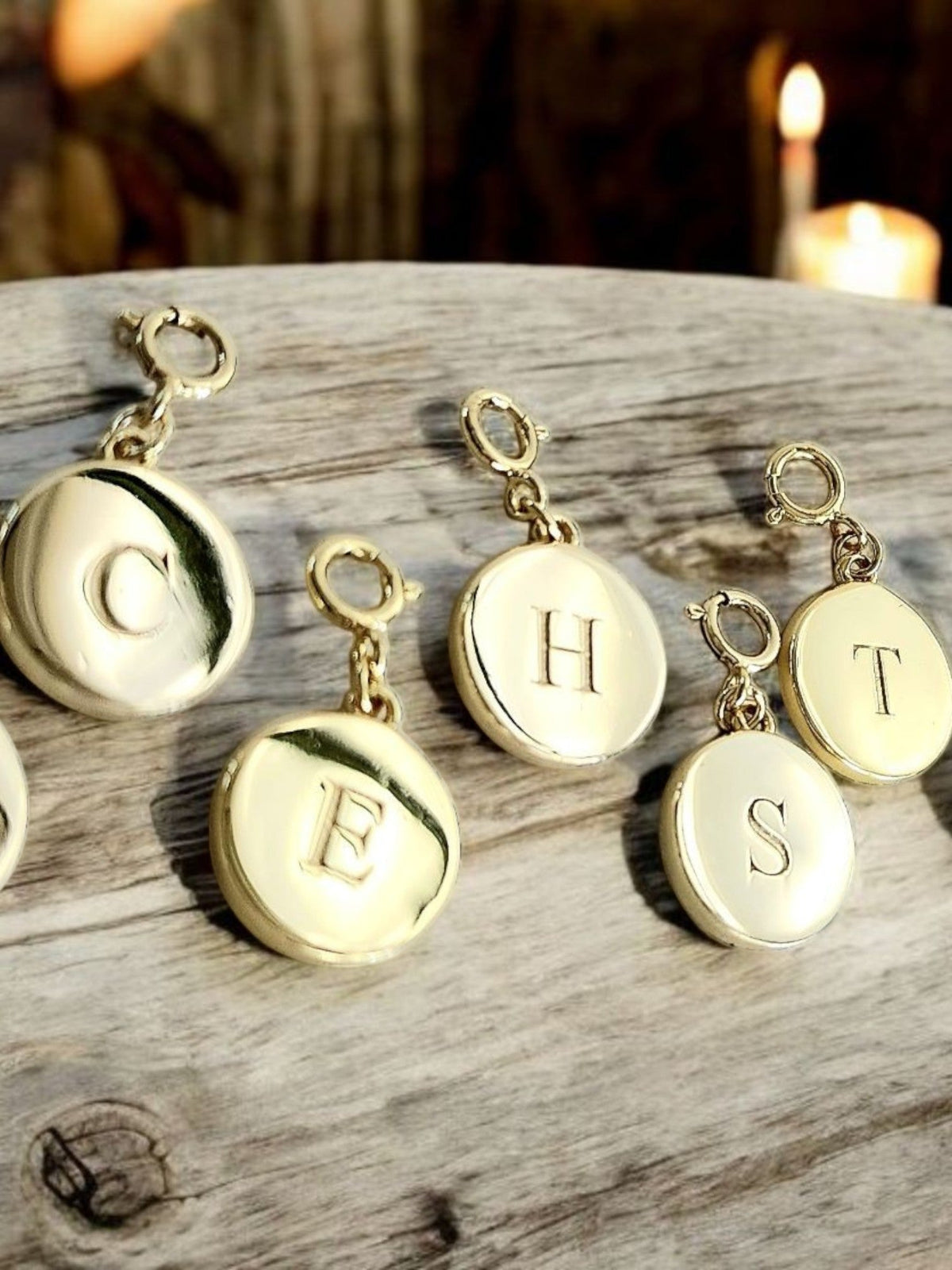Saints and Saviors Dainty Fancy Initial Clip on Charm letters C E H  and T on a wooden surface