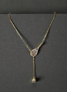 Delicate Gold Tennis Lariat necklace on a dark background